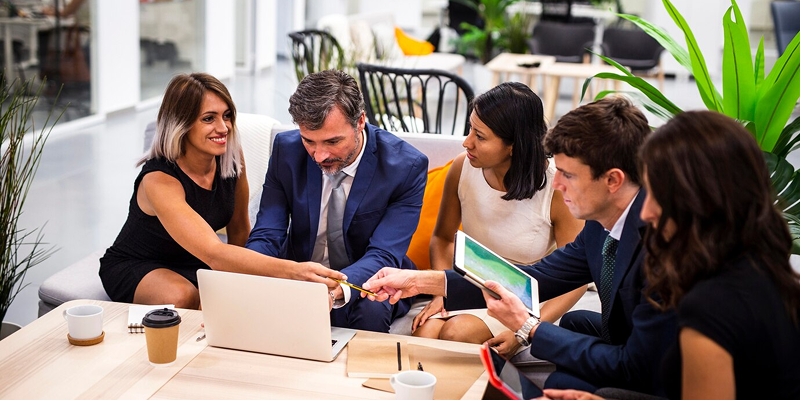 Four professionals discussing brand strategy and consulting services during a business meeting.
