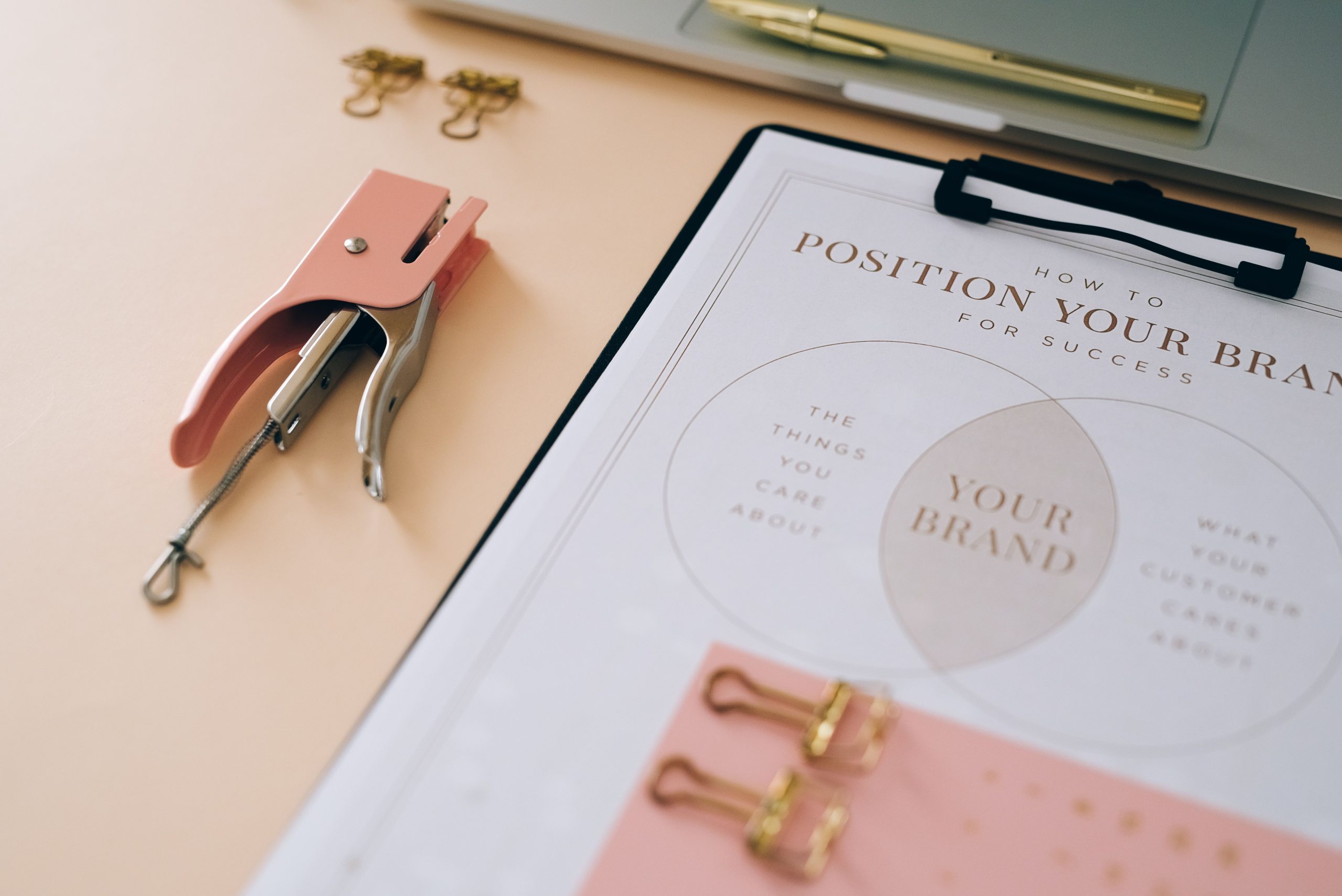 Paper holder displaying a page with the text "Position Your Brand" representing Brand Strategy and Consulting Services