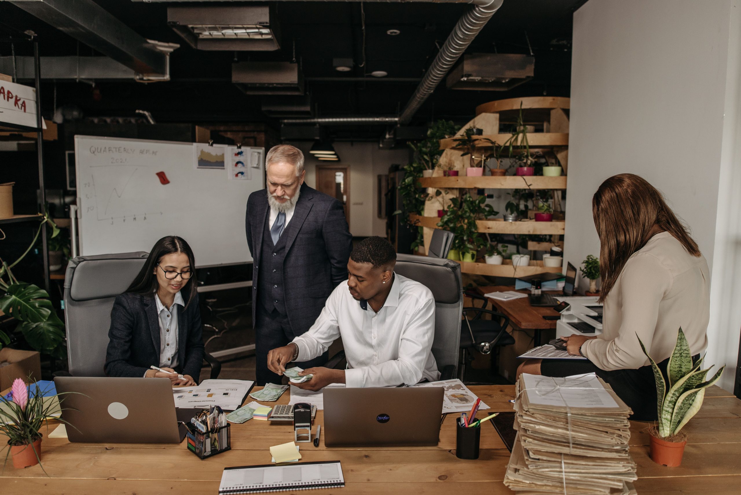 Four professionals discussing HR Consulting Services during a business meeting.