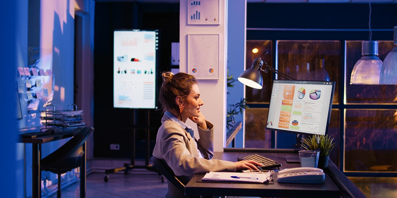 Professional woman sitting at desk working on digital marketing strategy content creation, SEO, and online branding"