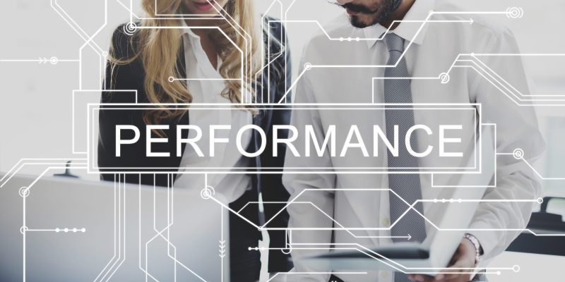 Male and female business professionals standing confidently against a technology-inspired background with digital connection lines and the word "Performance," representing OKR implementation, performance management, and business growth in the UAE.