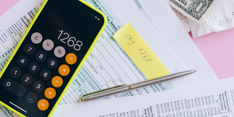 Payroll outsourcing services in UAE with payroll documents, calculator, and financial records for accurate salary processing
