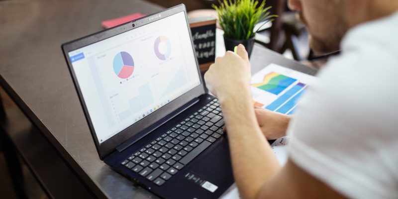 Professional reviewing business dashboards on a laptop to support OKR Implementation UAE and strategic goal tracking.