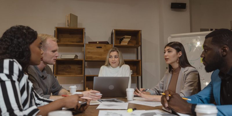 HR Outsourcing Services in UAE with a female HR consultant leading a meeting as her team sits around the office desk